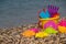 Plastic children`s toys for sand on the background of the sea. Kids toys. Plastic sand toys. Bright toys. Sand construction.