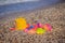Plastic children`s toys for sand on the background of the sea. Kids toys. Plastic sand toys. Bright toys. Sand construction.