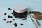 Plastic container with natural cosmetics on a wooden background.Grains of coffee and field herbs on the backdrop