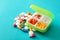 Plastic container with pills on color background