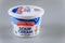 Plastic container of sour cream, produced by Friendly Farms USA on a gray isolated background