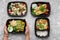 Plastic containers with delicious food on gray background