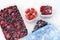 Plastic containers of frozen mixed berries in snow