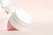 Plastic cream jar mockup on pink pedestal platform podium. Cosmetics packaging, product branding, lotion, mask, cleanser