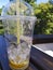 Plastic cup with lemonade remnants on the table outdoors.