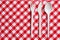 Plastic cutlery on checkered tablecloth