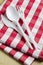 Plastic cutlery on checkered tablecloth