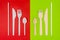 Plastic cutlery on red background and eco friendly disposable cutlery on green background