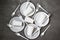 Plastic dishes, disposable tableware, plates, forks, glasses on a concrete grey background.