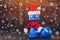 Plastic dumbbell with a red cap of Santa Claus in the gym, close-up against the background of snowflakes.