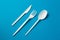 Plastic Fork, Spoon and Knive on Blue Background