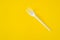 Plastic fork on yellow background