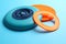 Plastic frisbee disks and ring on light blue background