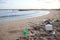 Plastic garbage, foam, and dirty waste on beach in summer day.