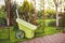 A plastic garden wheelbarrow sits on a freshly mown lawn in the garden, place for text