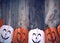 plastic garland on with carved figures of pumpkins, gray wooden background
