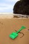 Plastic green spade on golden beach