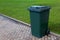 Plastic green wheeled recycling rubbish bin beside the road for rubbish collection