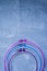 Plastic hoop on a light background under the concrete. Three hoops pink, blue, purple. View from above. Space under the text