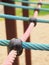 Plastic joint point of ropes in children spider web with screw. Detail of cross pink and blue ropes in safety climbing eq