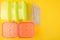 Plastic lunch boxes and drinking straws on yellow background, Colorful Plastic Containers