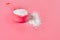 Plastic measuring spoon full of washing powder for cleaning cloth lies on pink countertop in laundry