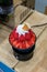 Plastic model of strawberry bingsu in black bowl on wooden table