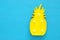 A plastic pineapple lamp with leds over blue wooden background. holiday summer concept.