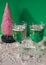 Plastic pink Christmas tree isolated on a green surface with fake snow.  New Year's concept and background.