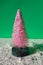 Plastic pink Christmas tree isolated on a green surface with fake snow.  New Year's concept and background.