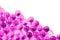 Plastic pink spherical ball capsules with selective focus on white background