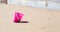 Plastic pink toy bucket left alone on the beach sand near water, blurred ocean on background - concept of vacation safety, drowni