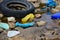Plastic pollution bottles net and car tire on ocean beach. Environment damage