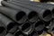 Plastic PVC pipes stacked main black pipes on heap of polyethylene pipes for a drain supply system for laying of city