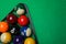 Plastic rack with billiard balls on green table, top view. Space for text