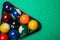 Plastic rack with billiard balls on green table, top view. Space for text