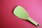 Plastic rice spoon cooking utensil used in the household and placed on a pink background