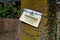 A plastic sign fixed to a sandstone pillar with barbed wire warns dog owners that livestock is loose in the field