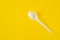 Plastic spoon on yellow background