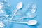 Plastic spoons, forks and cups as a disposable waste with copy space on bright blue background. Environmental pollution and litter