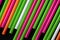 Plastic straws different colors on a dark background