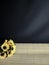 Plastic sunflower at wooden table and black background