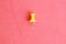 Plastic thumbtack on a red background