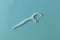 Plastic toothpick with dental floss on blue background