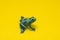 Plastic toy frog against yellow background