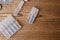 Plastic transparent ampoules with liquid medicine and tablets in blisters on a wooden background