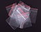 Plastic transparent zipper bag on black background. Block zip lock packaging. Empty polythene zip-lock sealed wrap