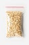 Plastic transparent zipper bag with full Oatmeal raw flakes isolated on white, Vacuum package mockup with red clip. Concept.