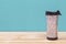 Plastic tumbler glasses or thermos travel cup  isolated on wooden background