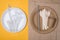 Plastic vs sustainable dinnerware choice concept. Top above overhead view photo of white plastic and wooden and paper utensils